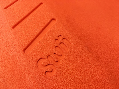 Close-up of textured orange surface of SUBLUE Swii kickboard with embossed logo.