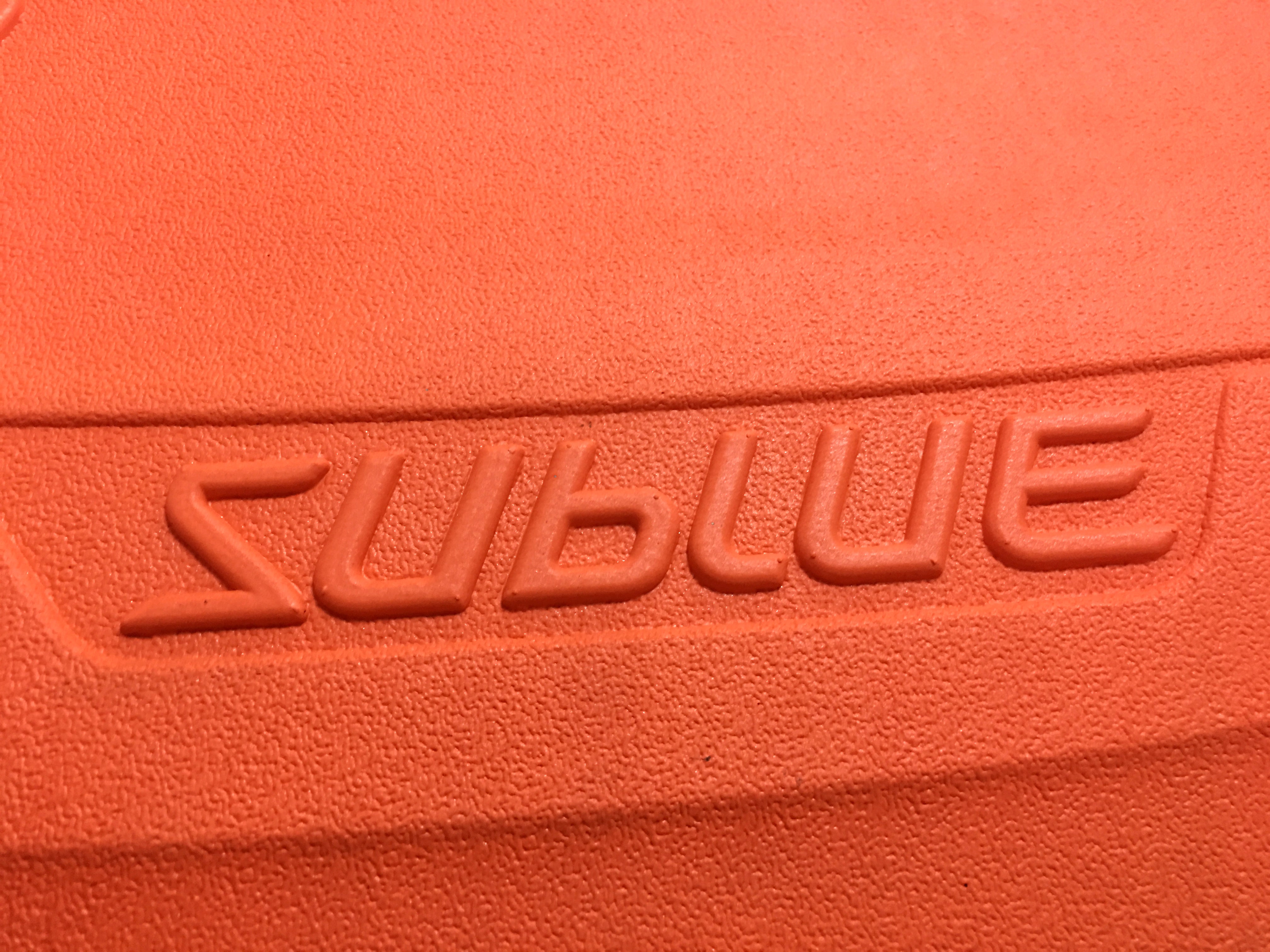 Close-up of textured orange surface on SUBLUE Swii kickboard with embossed logo.