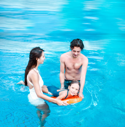 Child supported by two adults using SUBLUE Swii kickboard in a blue pool.